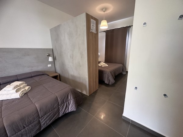 Due letti con divisione centrale in una stanza moderna.