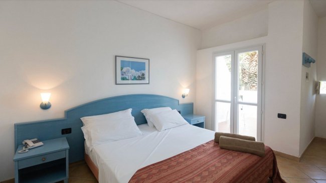 Camera da letto con letto matrimoniale e lampade.