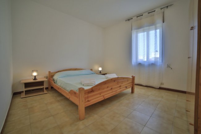 Camera da letto con letto matrimoniale in legno.