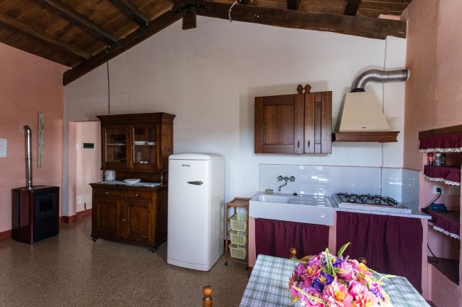 Cucina luminosa con frigorifero e mobili in legno.