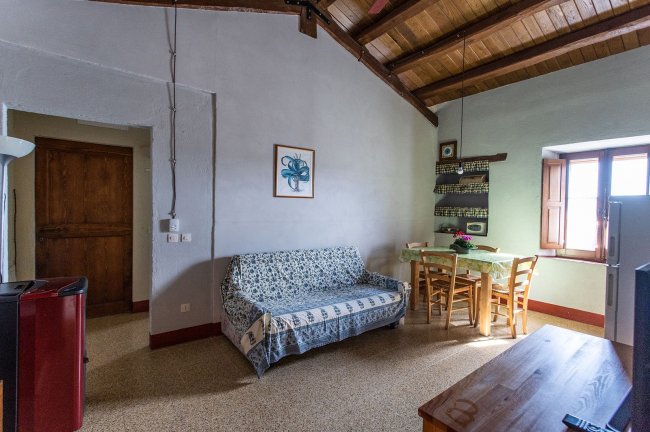 Salotto con sofa, tavolo e luci soffuse.