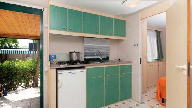 Cucina con mobili verdi e frigorifero.