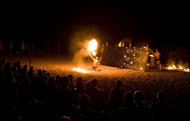Spettacolo di fuoco sulla spiaggia di notte.