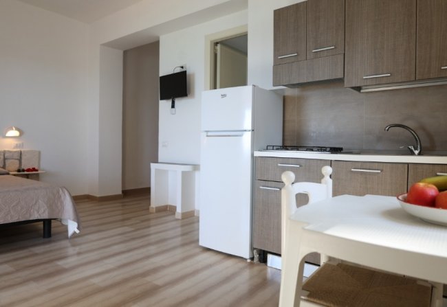 Una cucina moderna con frigo bianco e tavolo bianco.