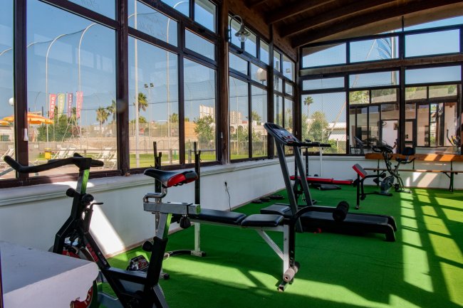 Palestra con tapis roulant, panca e attrezzi vari.