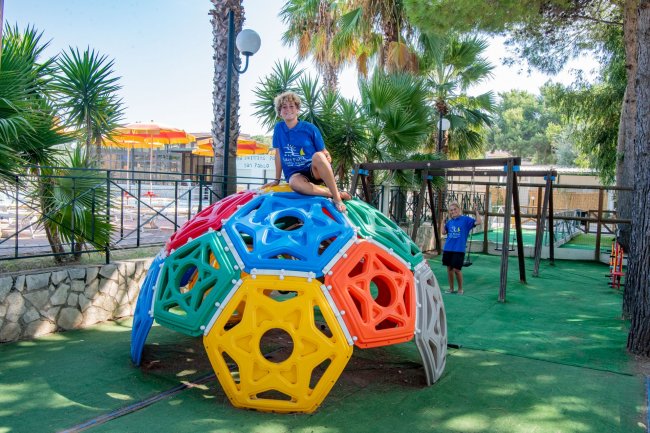 Bambini su una struttura da arrampicata colorata.