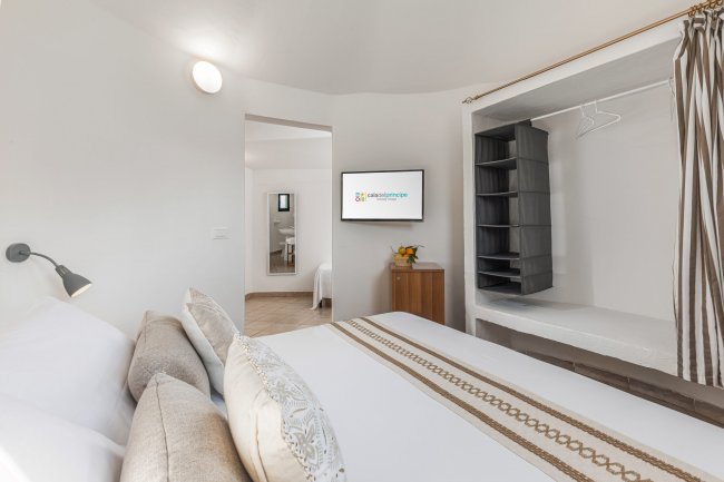 Camera da letto con armadio e TV sul muro.