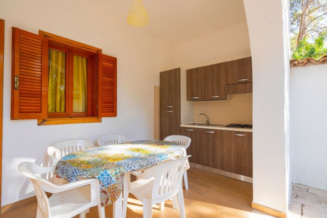 Cucina con tavolo e sedie bianche in veranda.