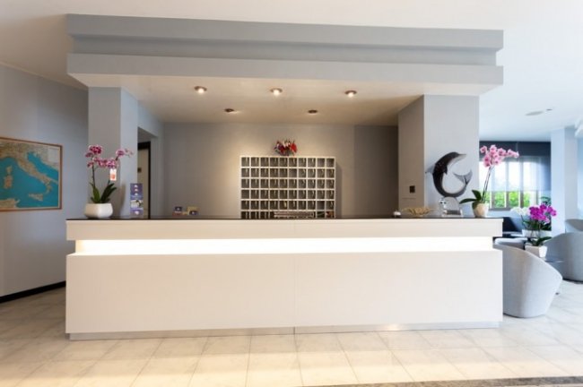 Reception minimalista con un mappamondo decorativo.