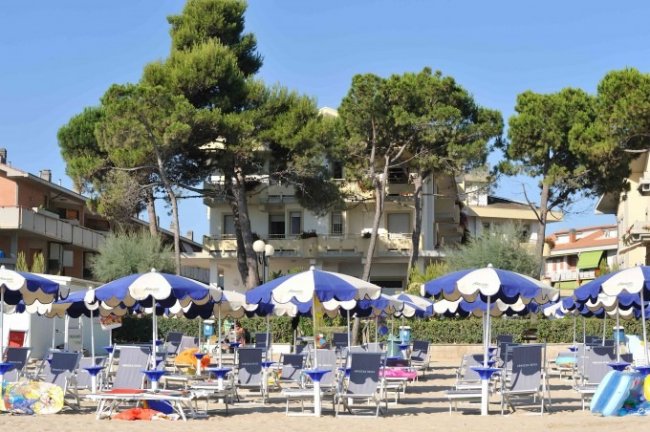 Spiaggia con ombrelloni blu e bianchi e sdraio.