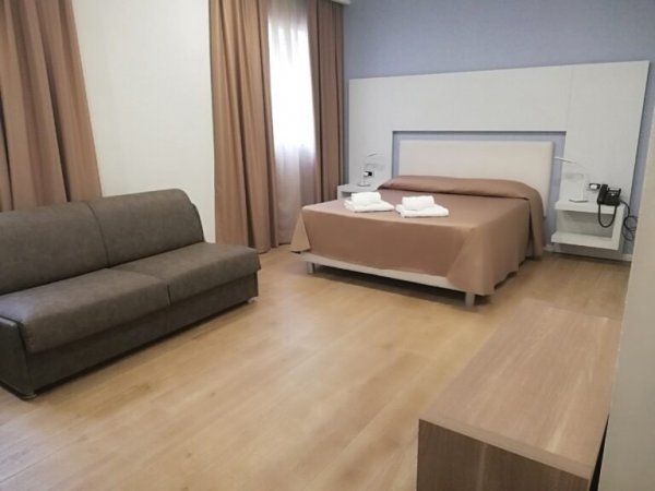 Camera con letto matrimoniale e divano.