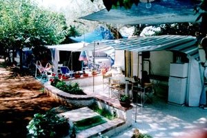 Area camping con tende e veranda esterna.