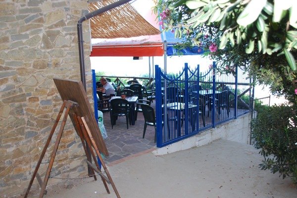 Terrazza con tavoli e sedie sotto una tettoia.