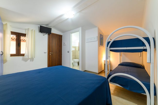 Camera con letto a castello e matrimoniale, bagno annesso.