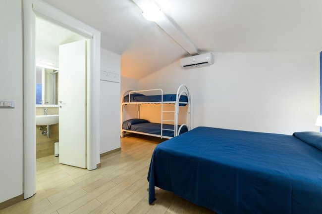 Camera con letto a castello, bagno aperto.