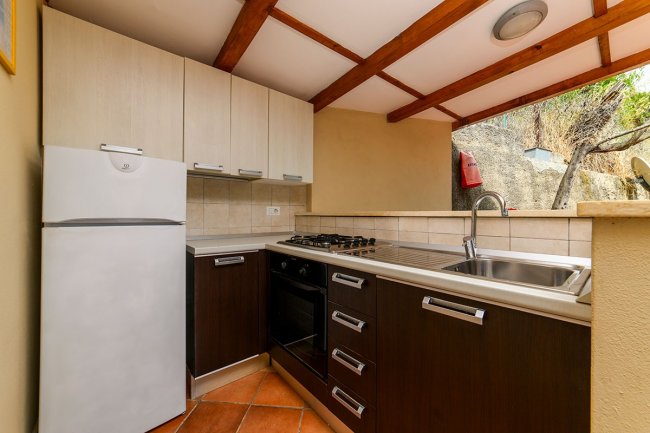 Cucina compatta con frigorifero e lavello.