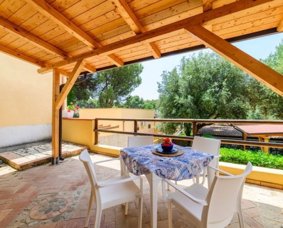 Terrazza coperta con tavolo apparecchiato.