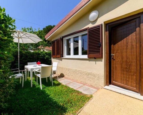 Entrata di casa con giardino e ombrellone.