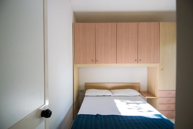 Letto matrimoniale con armadio a muro.