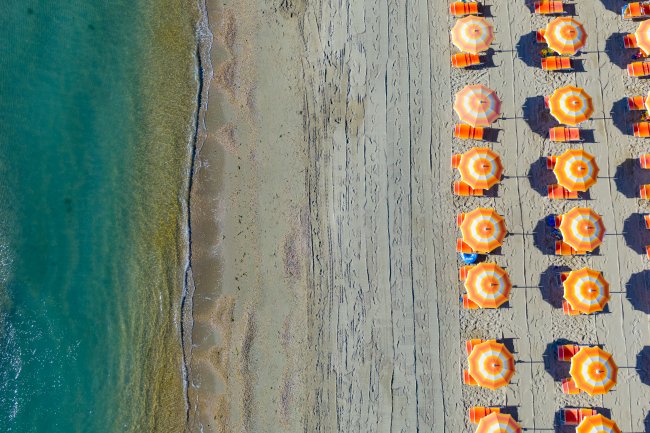 Ombrelloni arancioni sulla spiaggia vicino al mare.