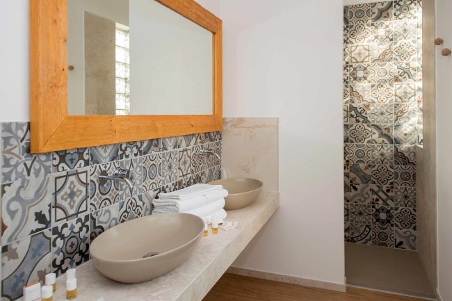Bagno con doppio lavabo e piastrelle decorate.