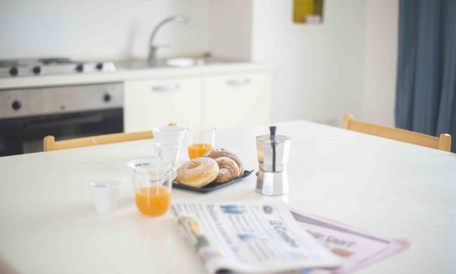Colazione con caffè, succhi e ciambelle.