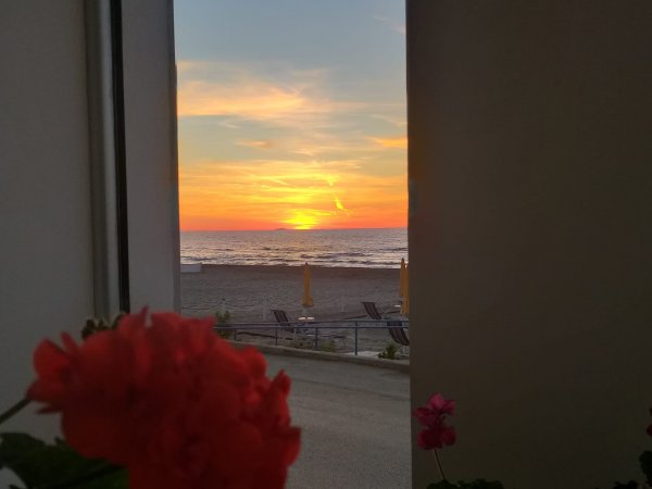 Tramonto visto da una finestra con vista mare.