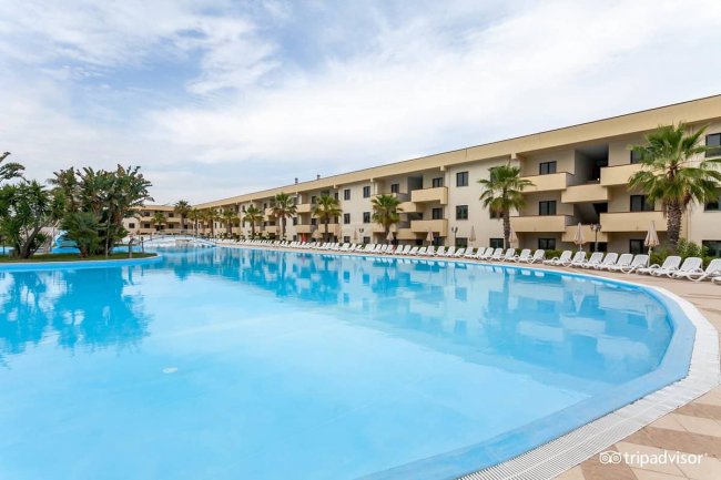Grande piscina all'aperto con sedie a sdraio.