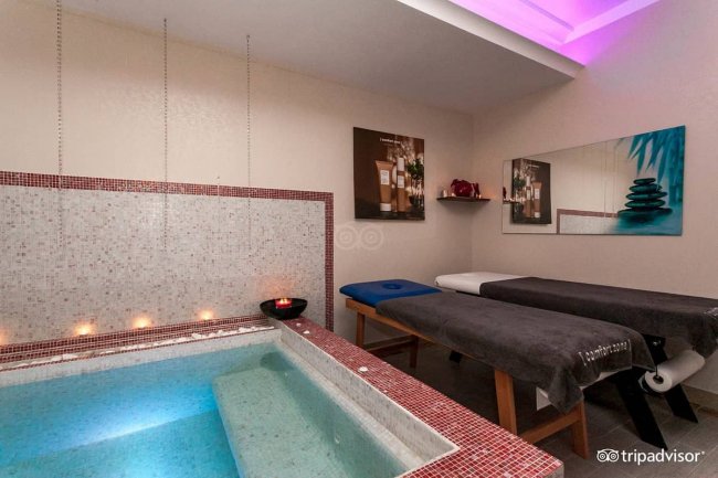 Sala benessere con piscina e lettini.