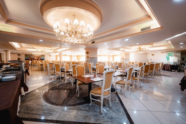 Ampia sala da pranzo con eleganti lampadari.