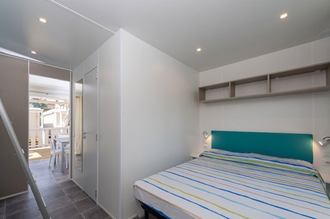 Camera con letto matrimoniale e mensole.