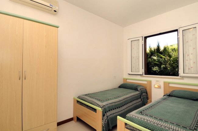 Camera con due letti singoli e finestra.