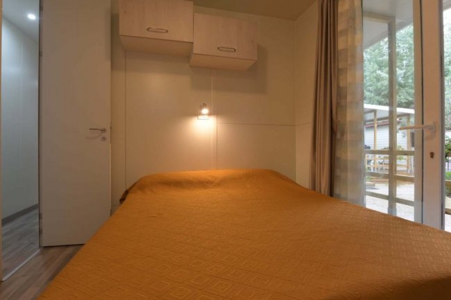 Camera con letto matrimoniale e mobili chiari.