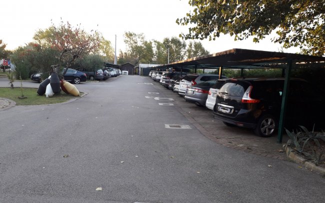 Parcheggio con auto sotto una tettoia.