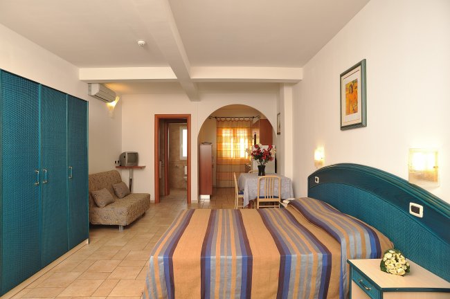 Camera d'albergo con letto matrimoniale e divano.