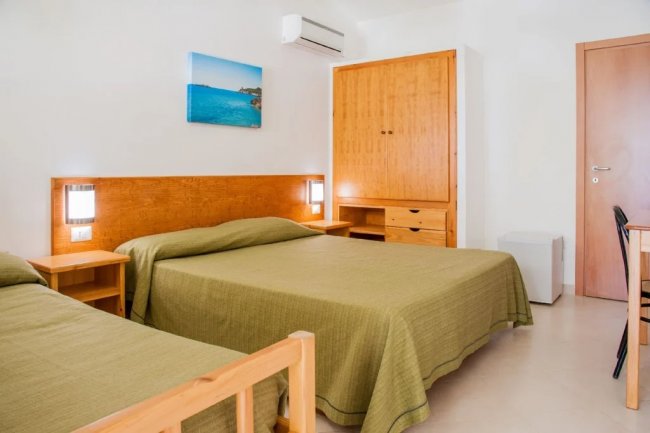 Camera d'albergo con letti e armadio.